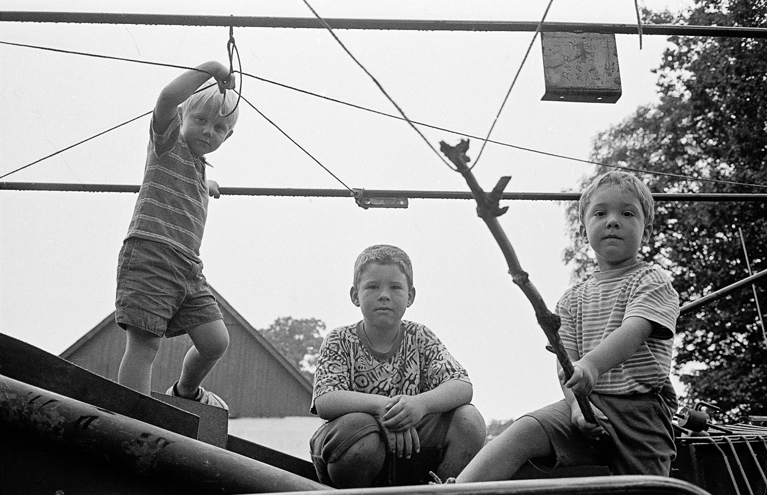© Torbjörn Helgesson Tre pojkar på maskin. fotografi av Torbjörn Helgesson.